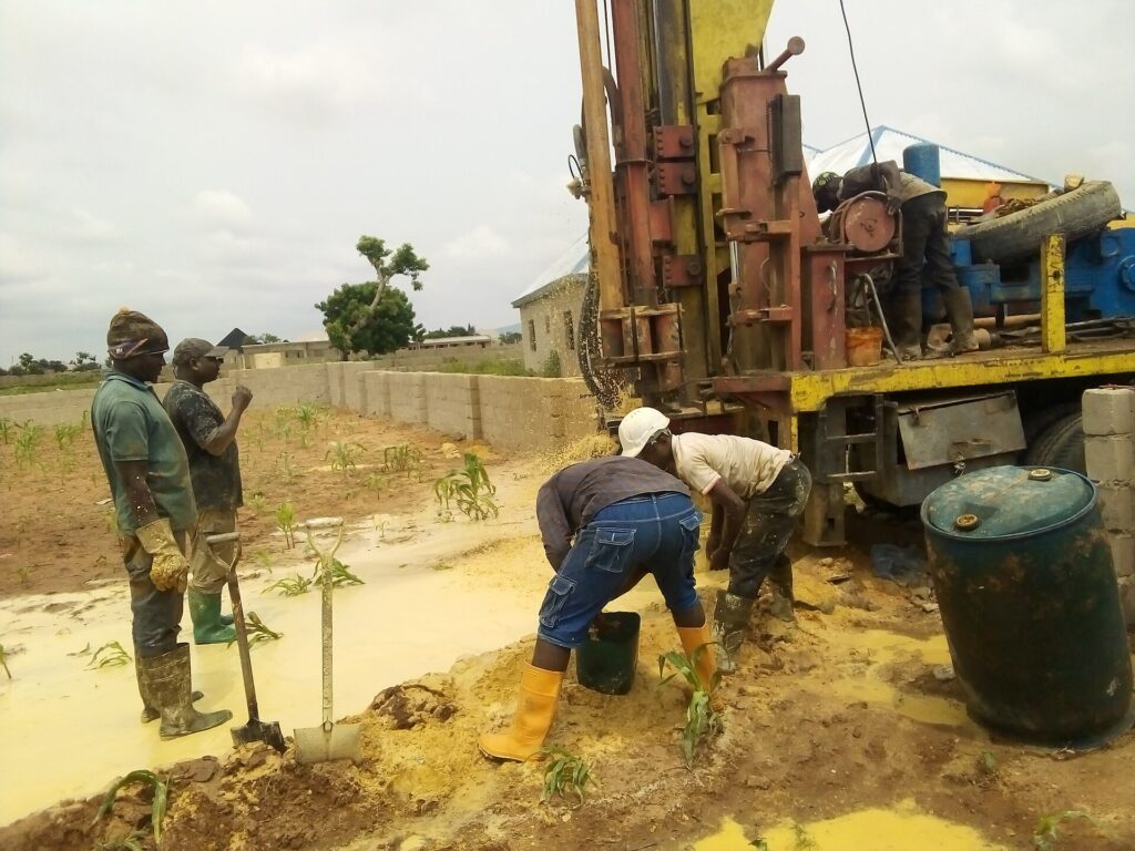 Borehole drilling rig at work on a sandy site