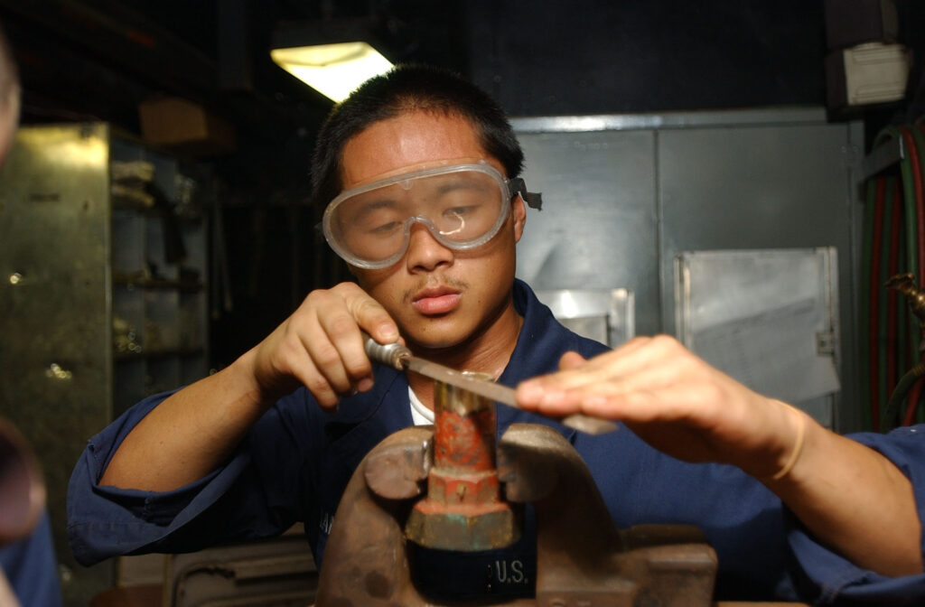 A technician preparing the end of a copper pipe for soldering