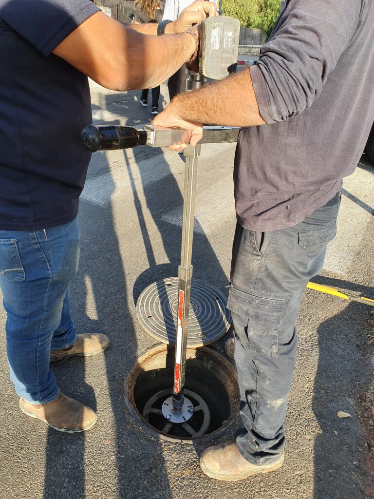 Plumbers working on a water main at a street chamber
