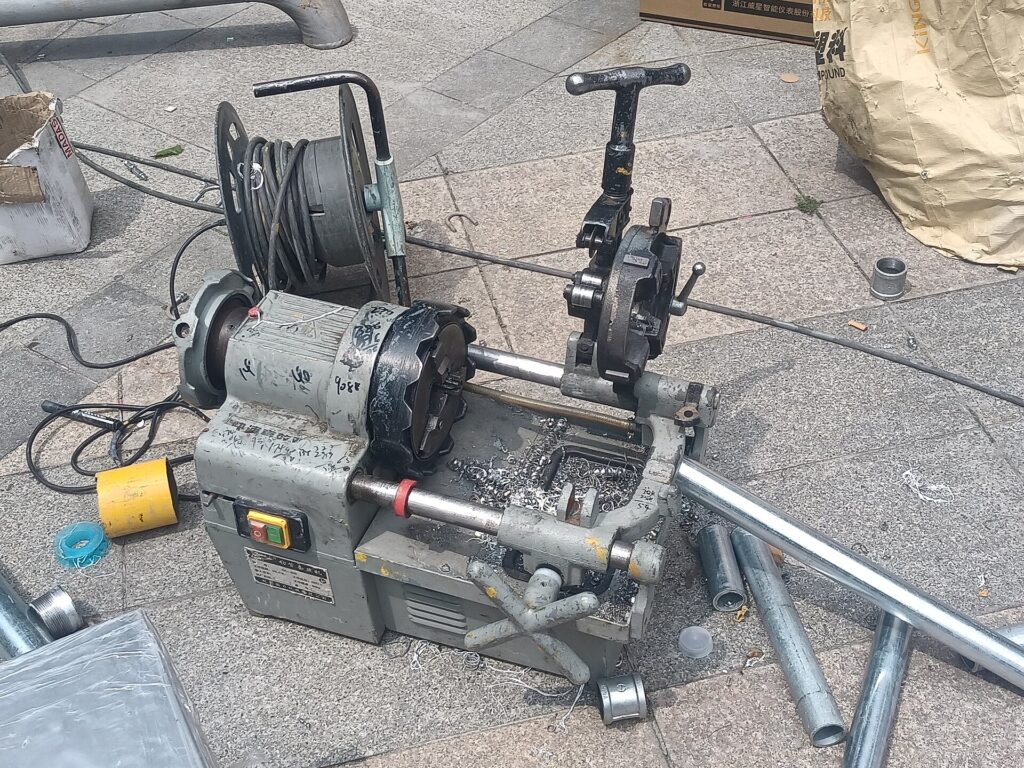 Pipe cutting and threading machine on a work site