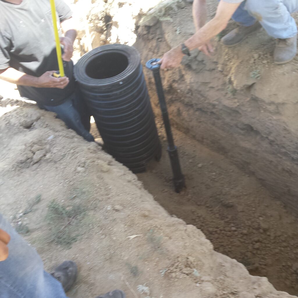 Laying corrugated drainage pipe in an open trench
