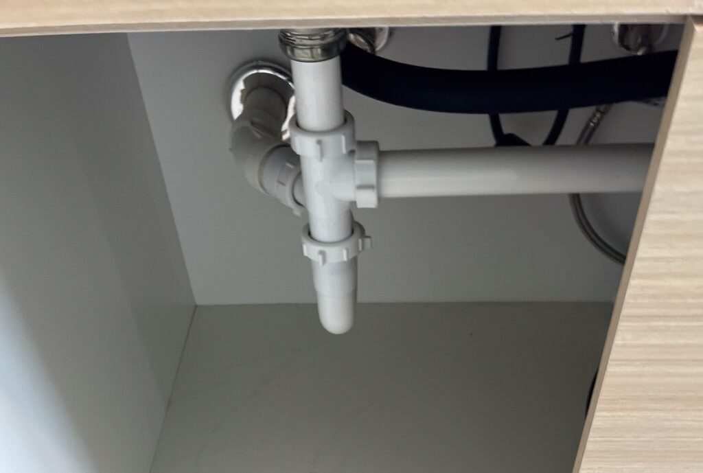PVC waste piping under a kitchen sink