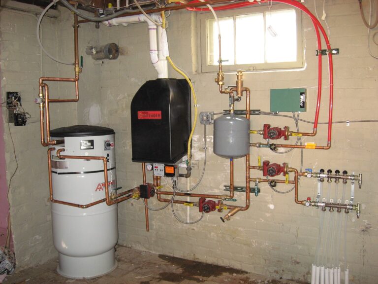 Wall-mounted water heating unit with valves and pipework